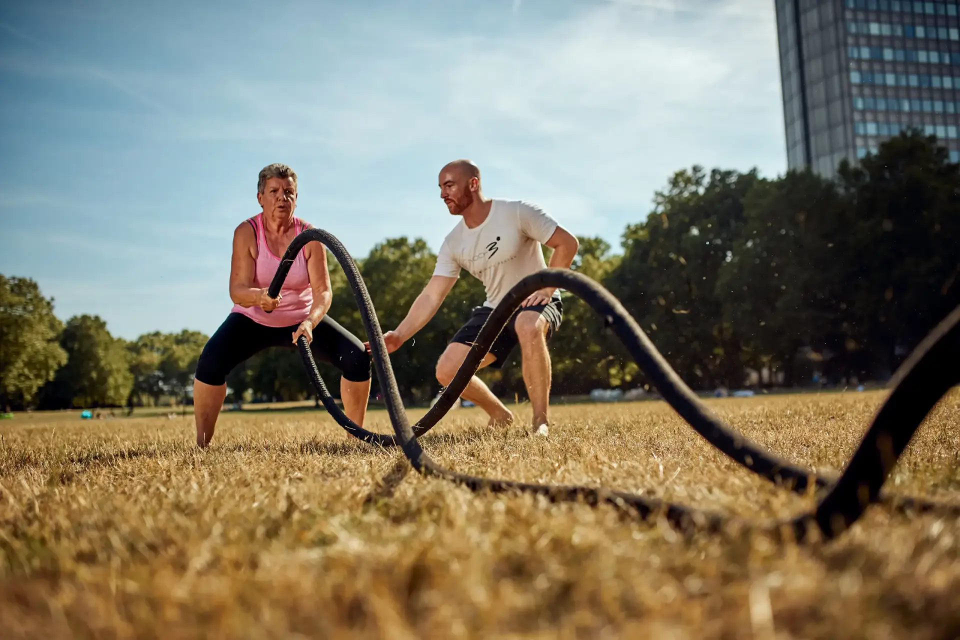 Personal Trainer trainiert mit einer Kunden an den Battleropes